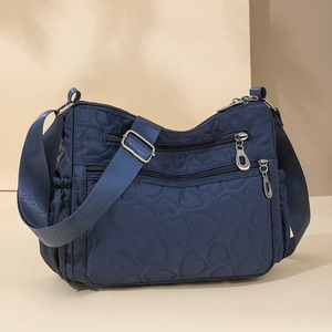 Navy blue nylon crossbody bag with heart quilting and multiple zipper pockets