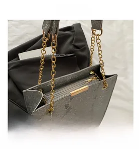 Detail of grey snakeskin pattern handbag with gold chain strap and interior zipper pocket