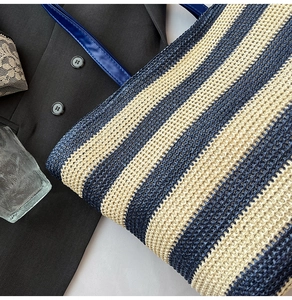 Détail de la texture tissée bleue et beige sur un grand sac cabas rayé pour l'été