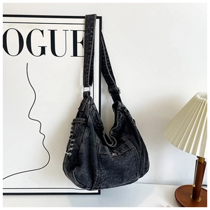 Detail of vintage denim bag featuring utility pockets and fringe edges in a studio setting