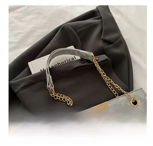 Detail view of the gray snake pattern tote featuring a gold chain and leather strap