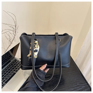 Detail of black tote bag with white stitching and floral silk scarf on the handle