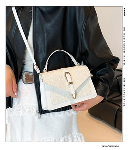 Détail du sac à bandoulière en similicuir serpent blanc avec boucle dorée sur modèle