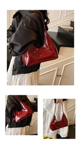 Detail of burgundy patent leather baguette bag featuring gloss finish and silver charm