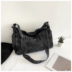 Detail of black vintage denim tote bag featuring frayed edges and metal buckle accents