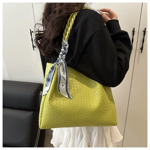 Détail du sac cabas tressé vert avec un élégant foulard en soie imprimé France en accessoire