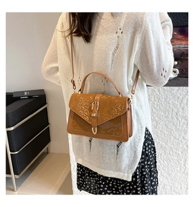 Detail shot of camel leather shoulder bag with snakeskin pattern flap and metal buckle