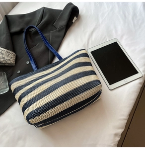 Détail macro d'un grand sac cabas tissé à rayures bleues et beige avec ses poignées