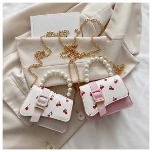 Detail of pink and grey cherry print mini bags with pearl handles and gold chains