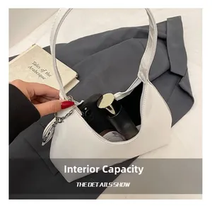 Internal capacity of white patent leather handbag showing space for phone and cosmetics