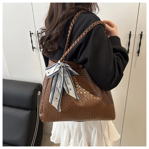 Détail du sac cabas tressé marron avec foulard en soie France Paris sur la poignée