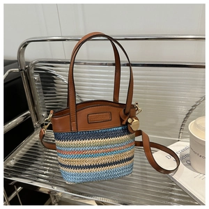 Détail du sac seau tissé multicolore avec poignées en cuir et plaque de logo en métal