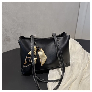 Detail of black tote bag with white contrast stitching and elegant printed silk scarf