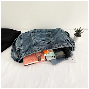 Detail view of denim bag interior showing large capacity for tablet and daily items