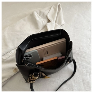 Detail of spacious black tote bag interior showing capacity for makeup and notebook