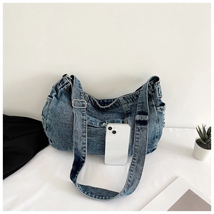 Detail of blue denim shoulder bag with adjustable strap and contrast stitching decoration