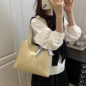 Large woven beach tote bag with leather straps and decorative scarf for summer travel