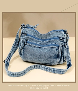 Detail view of multi-layered blue denim crossbody bag with vintage washed texture