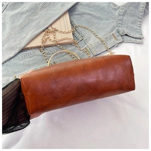 Vista laterale di una borsa in pelle vintage marrone con catena dorata e manico tondo