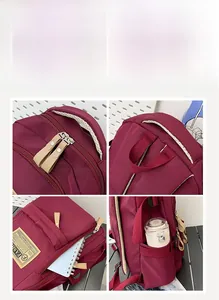 Close-up of wine red backpack with reinforced handle, smooth zippers, and side pockets