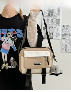 Detailed shot of a beige patchwork messenger bag with an octopus plush charm on a model