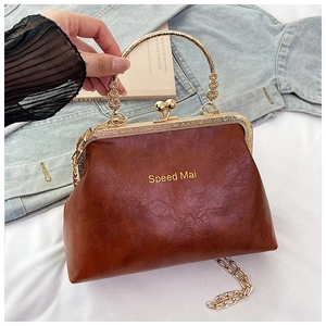 Dettaglio borsa vintage marrone con manico dorato decorato e tracolla a catena
