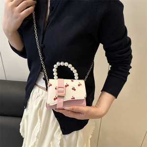 Pink and white crossbody bag with cherry prints, pearl handle and gold chain strap