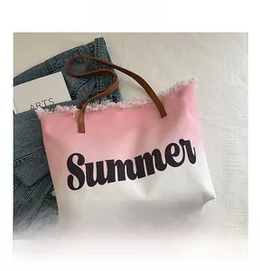 Detail of pink gradient canvas beach tote bag with fringe edge and leather handles
