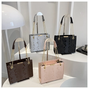 Detailed group view of four snakeskin textured crossbody bags with gold chain straps