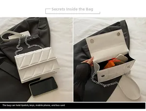 Détail d'un sac à main blanc matelassé avec chaîne argentée et fermoir magnétique