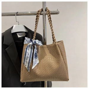 Détail du sac cabas kaki avec texture croco, anses tressées et foulard en soie imprimé