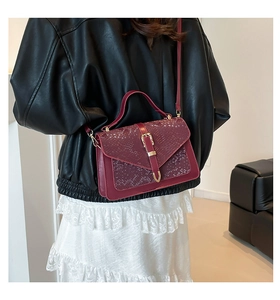 Detailed close-up of dark red snakeskin embossed flap and elegant gold metal clasp