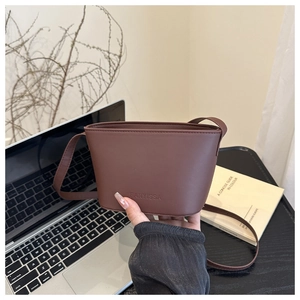 Close-up of a brown bucket bag showing the embossed FANYISSA logo and PU texture