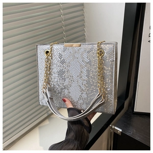 Detailed close-up of snake skin embossed silver grey square bag with gold metal lock