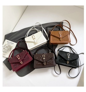 Flat lay of small crossbody bags in five colors with snake pattern and metal lock detail