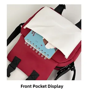 Detailed view of red utility crossbody bag showing front pocket storage and buckle