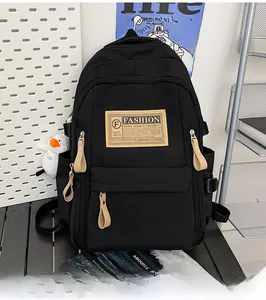 Detail of durable black nylon backpack with beige fashion tags and zipper pulls