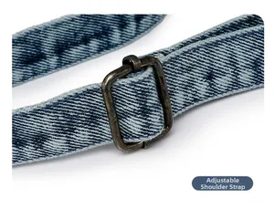 Detail of adjustable denim shoulder strap with vintage bronze metal buckle and twill weave