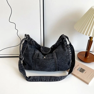 Black denim tote bag with vintage frayed edges shown in a cozy lifestyle setting