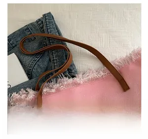 Detail of pink canvas tote bag showing comfortable brown leather straps and frayed fringe edges