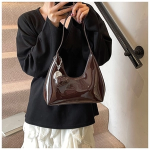 Dark brown patent leather baguette bag with heart charm shown in a mirror selfie