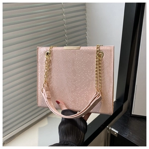 Detailed view of pink snake-embossed leather tote bag with gold chain strap