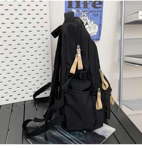 Side view of black nylon backpack showing multi-layer zippers and breathable mesh straps