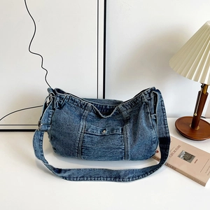 Retro washed denim shoulder bag with front metal buckle pocket in a cozy home setting