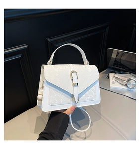 Close-up of stylish white snake print handbag with elegant metal lock and leather strap