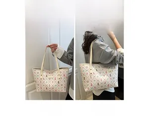 Detail showing cartoon bear print on white tote bag and shoulder strap versatility