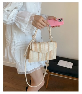Detail of colorful woven straw handbag showing the striped texture and ring handle