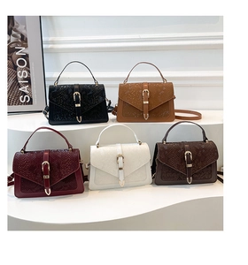 Close-up of textured flap handbags with gold shield clasps in five elegant colors