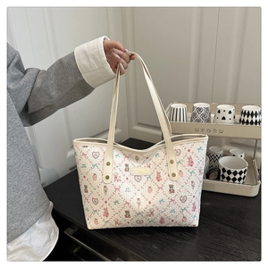 Detail of cute cartoon bear prints and textured material on a cream tote bag