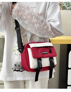 Red and white canvas messenger bag with plastic buckle and gray octopus plush keychain
